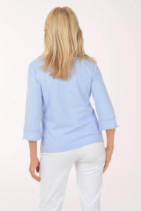 Woman wearing a light blue top with a white background