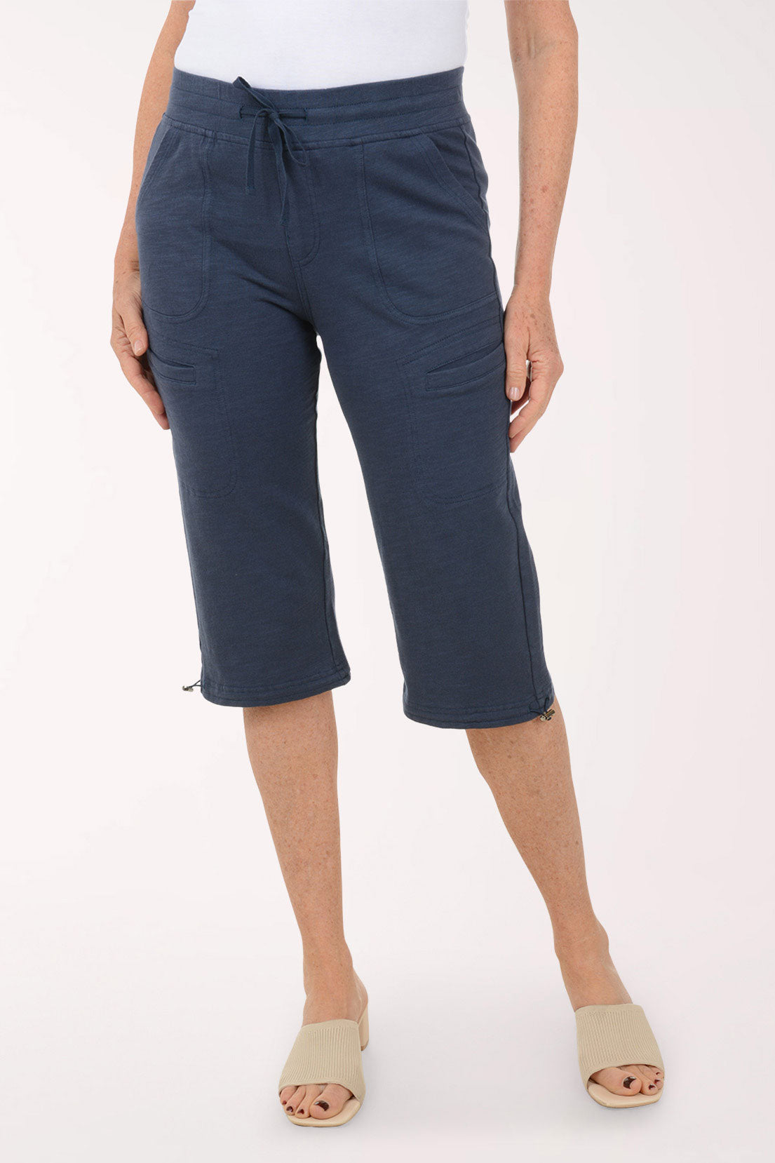 Person wearing navy blue capri pants on a white background