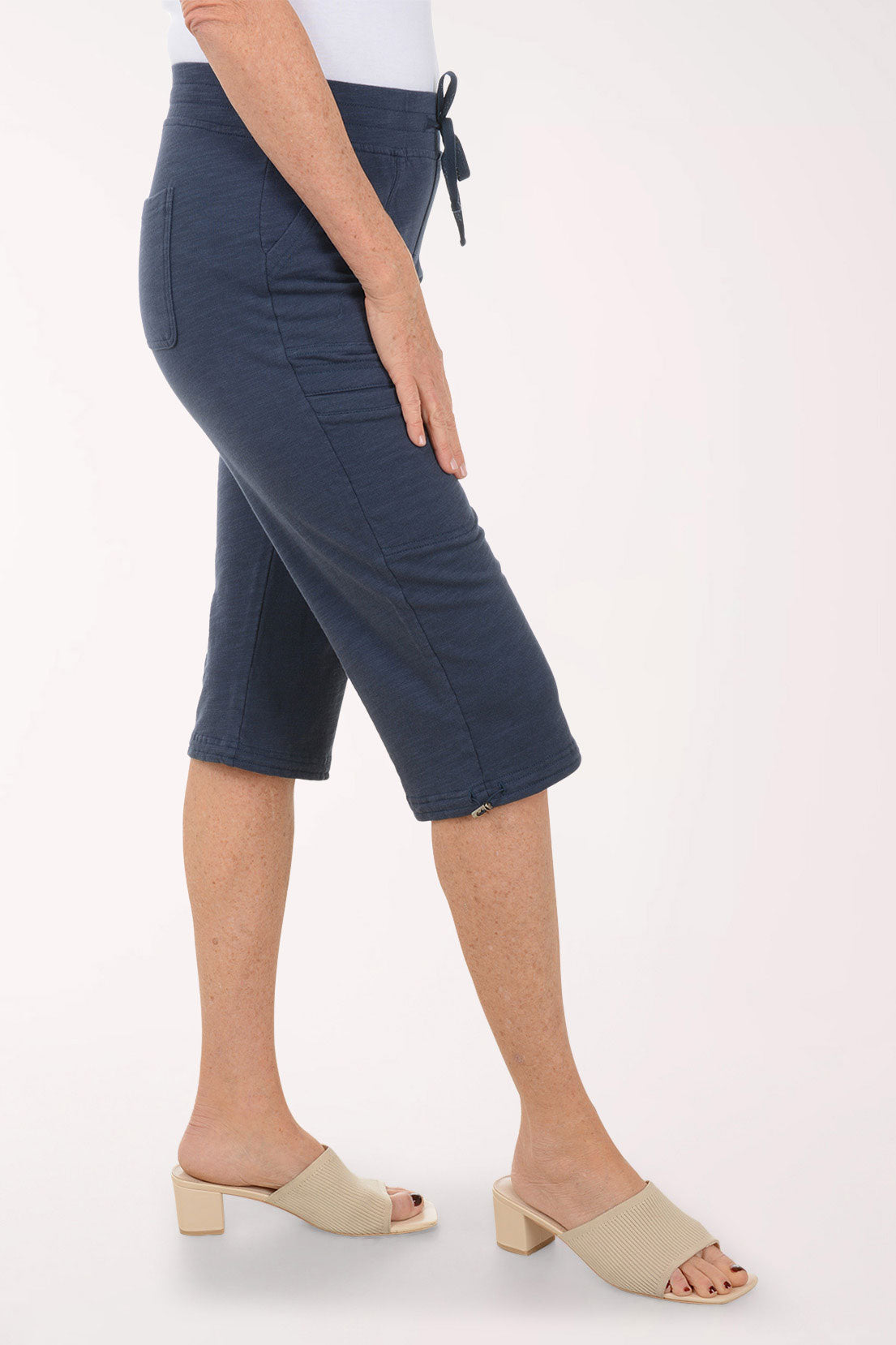 Person wearing navy blue capri pants on a white background