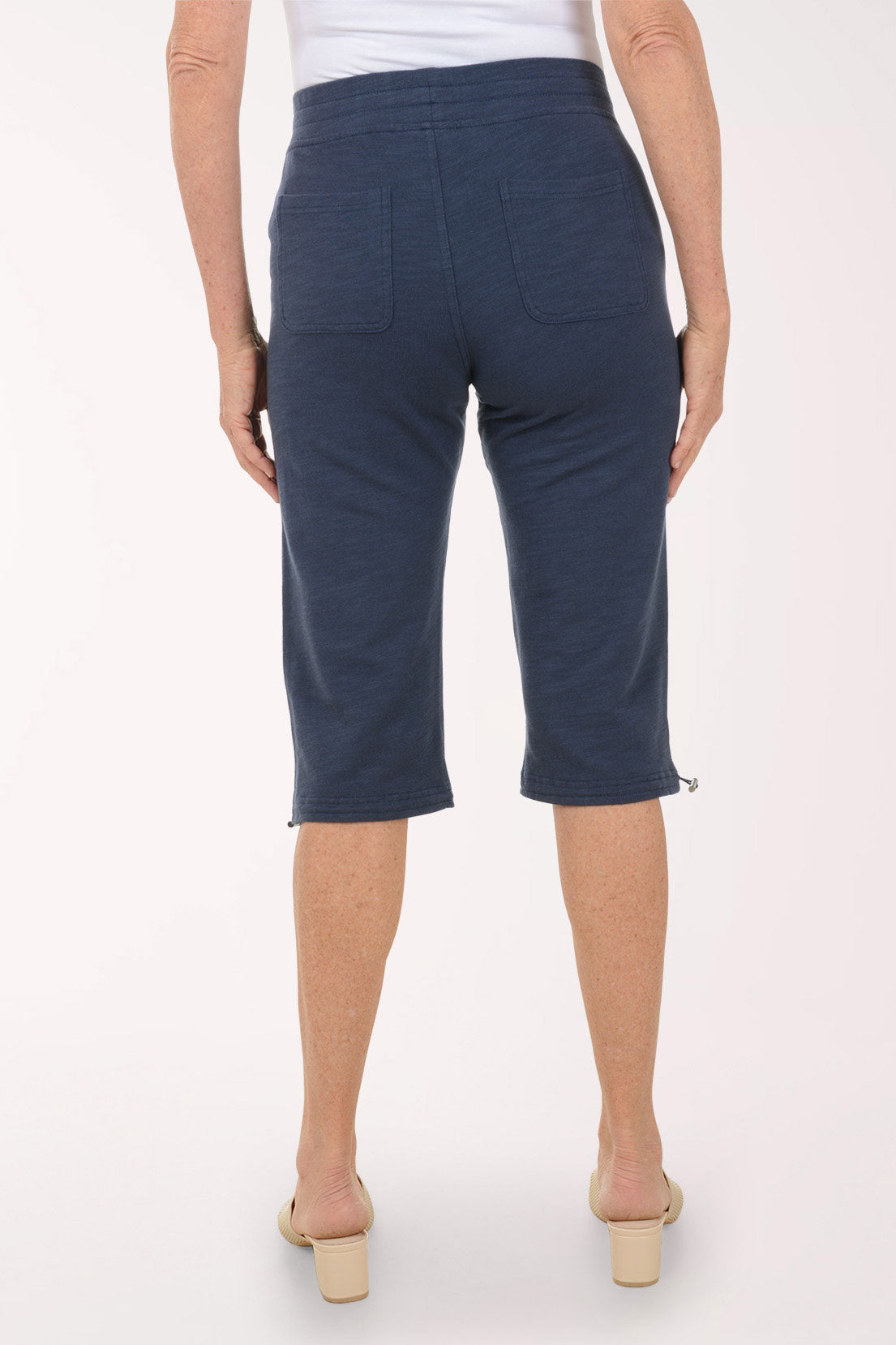 Person wearing navy blue capri pants on a white background