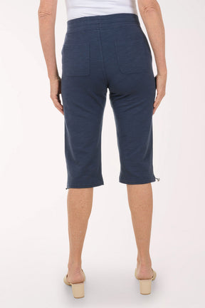 Person wearing navy blue capri pants on a white background
