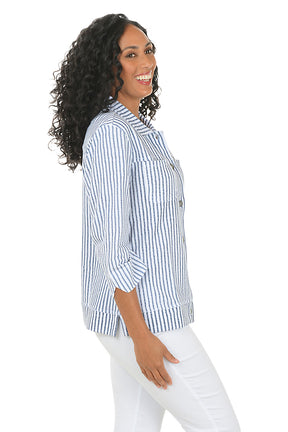 Woman wearing a blue and white striped shirt on a white background. Side shot.