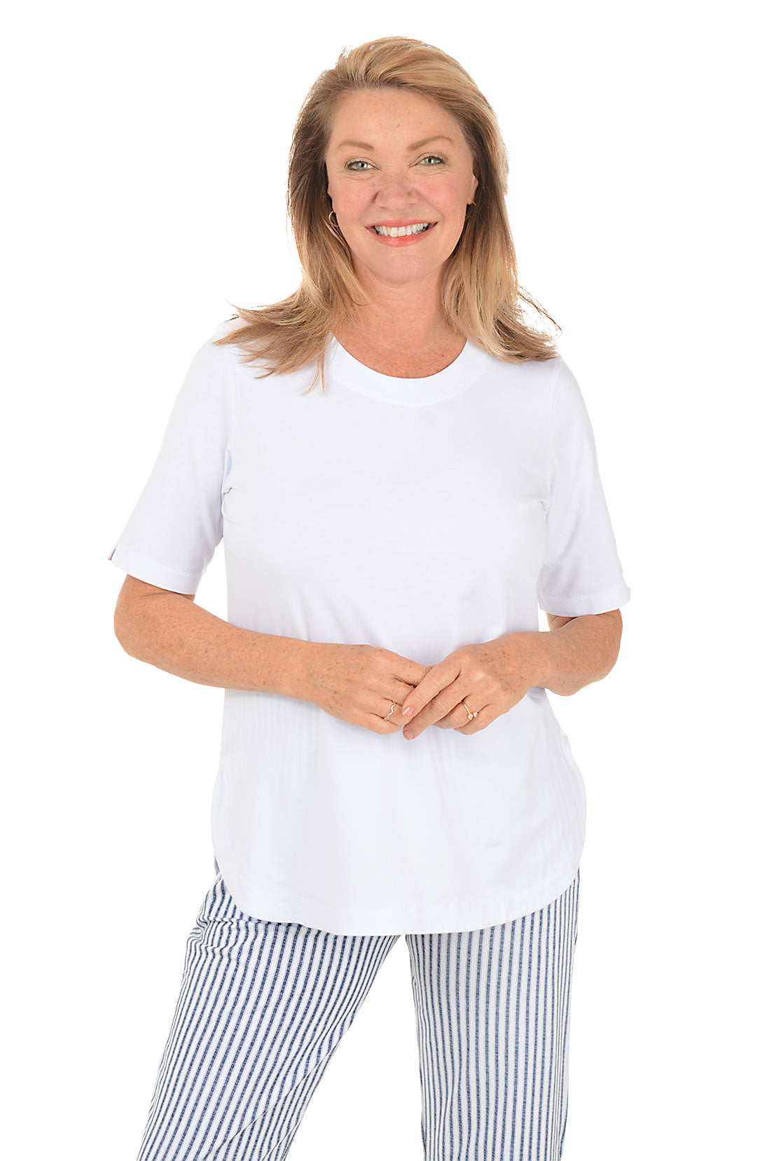 Woman wearing a white top and striped pants on a white background.
