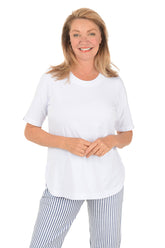 Woman wearing a white top and striped pants on a white background.