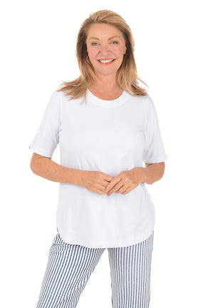 Woman wearing a white top and striped pants on a white background.