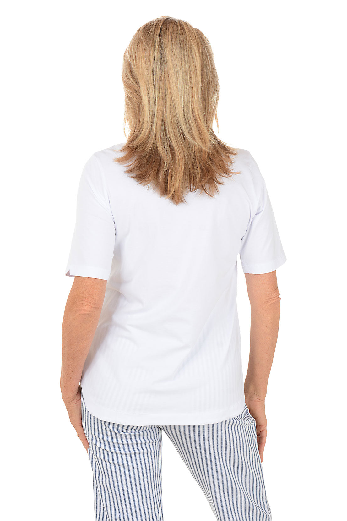 Woman wearing a white top and striped pants on a white background. Back shot.