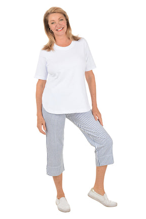 Woman wearing a white top and striped pants on a white background. Second full length shot.