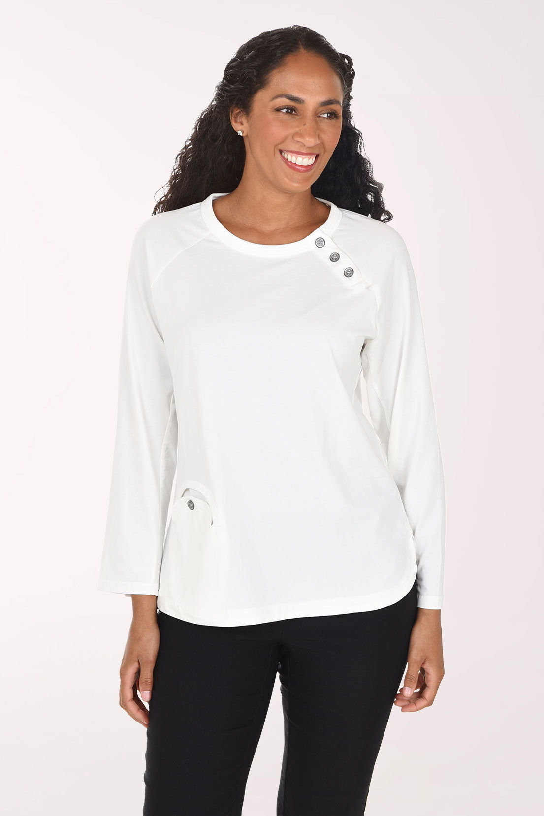 Woman wearing a white long sleeve top with three button embellishment