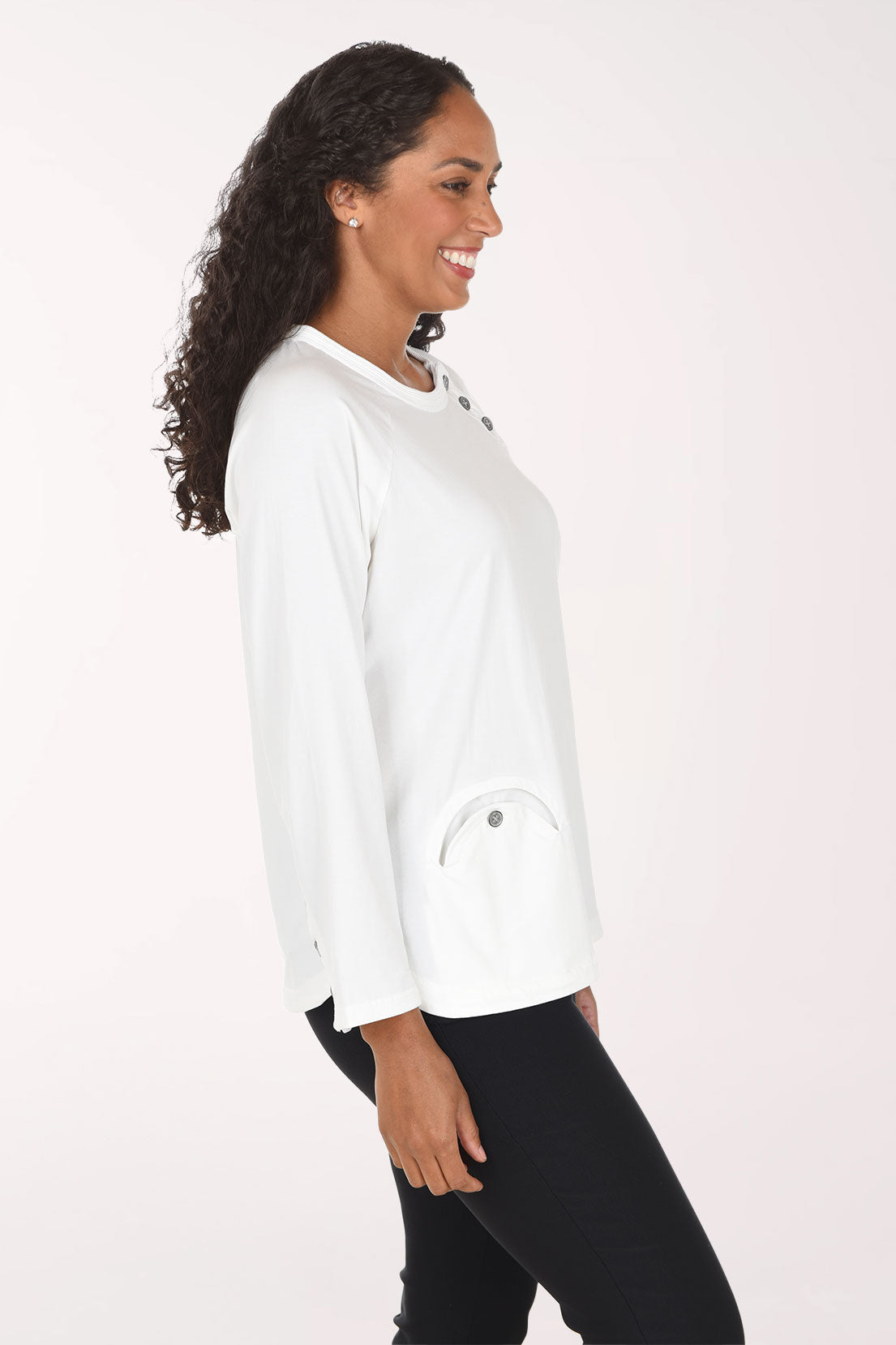 Woman wearing a white long sleeve top with three button embellishment
