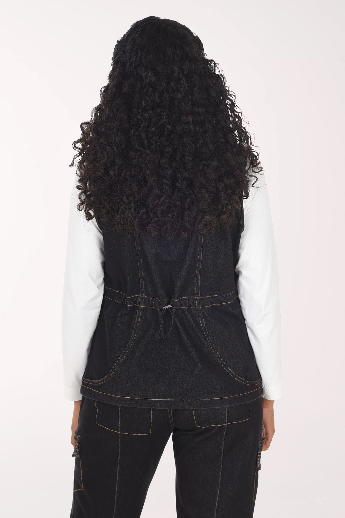 Woman wearing a sleeveless black denim vest