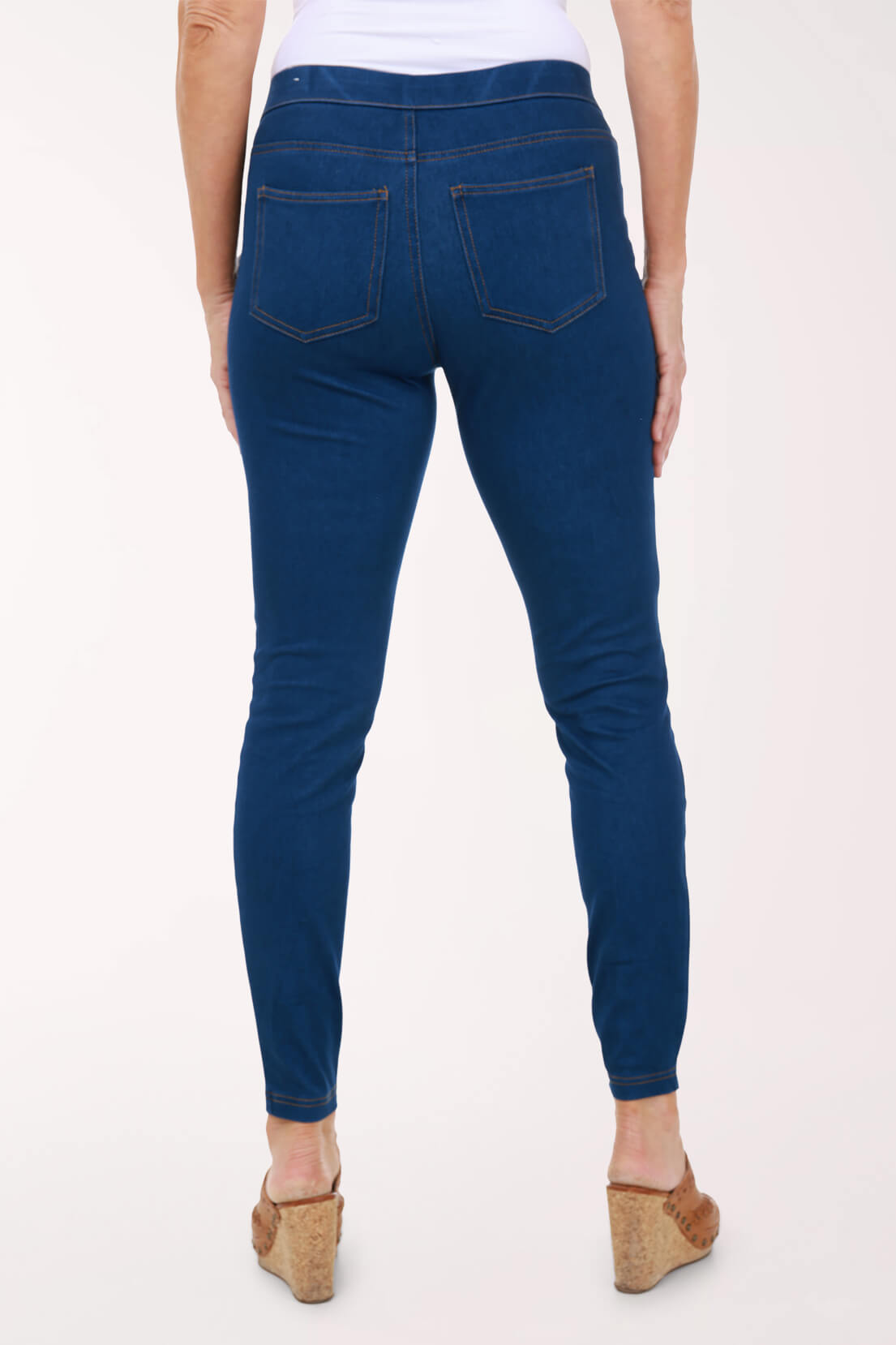 A back view of medium wash skinny pull-on jeggings showing the two back patch pockets.