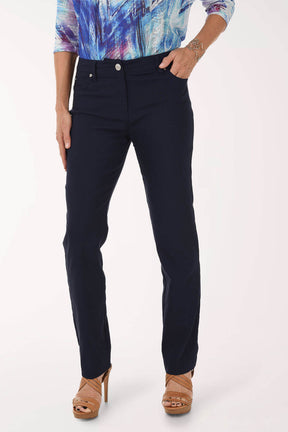 Person wearing navy pants with a colorful top on a white background