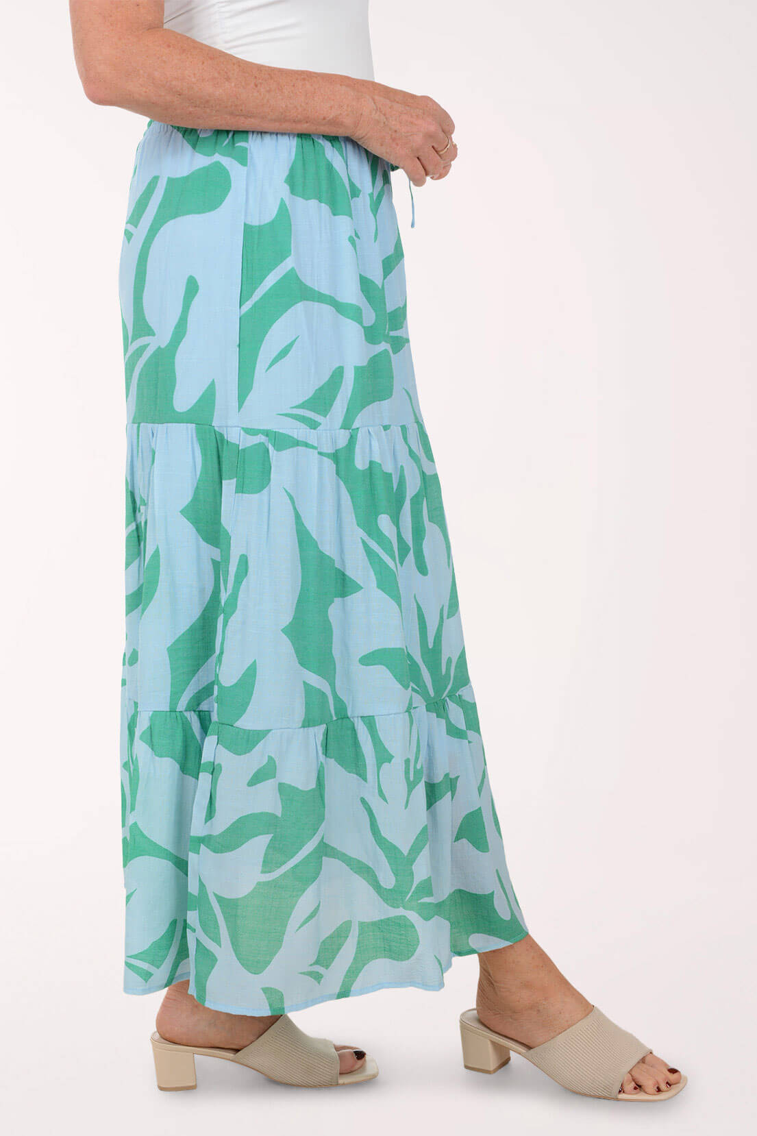 Woman wearing a green and blue patterned skirt on a white background