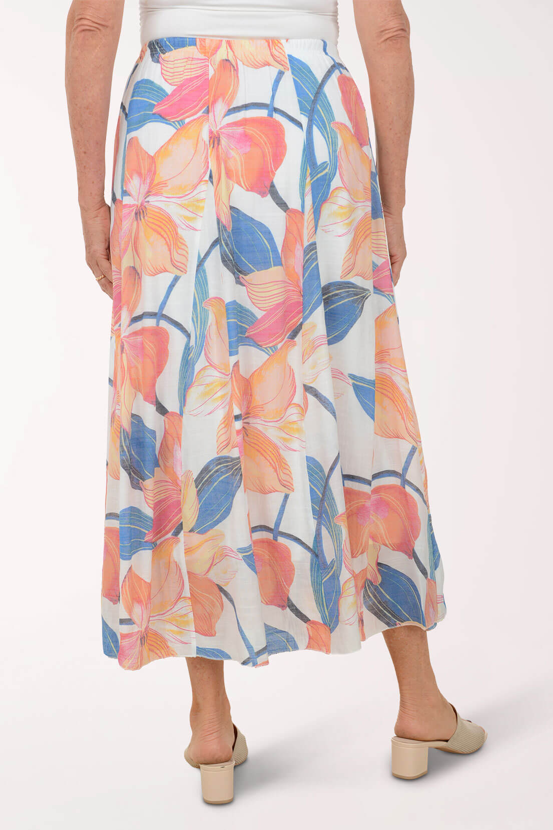Woman wearing a colorful floral skirt on a white background