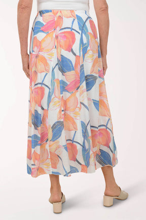 Woman wearing a colorful floral skirt on a white background
