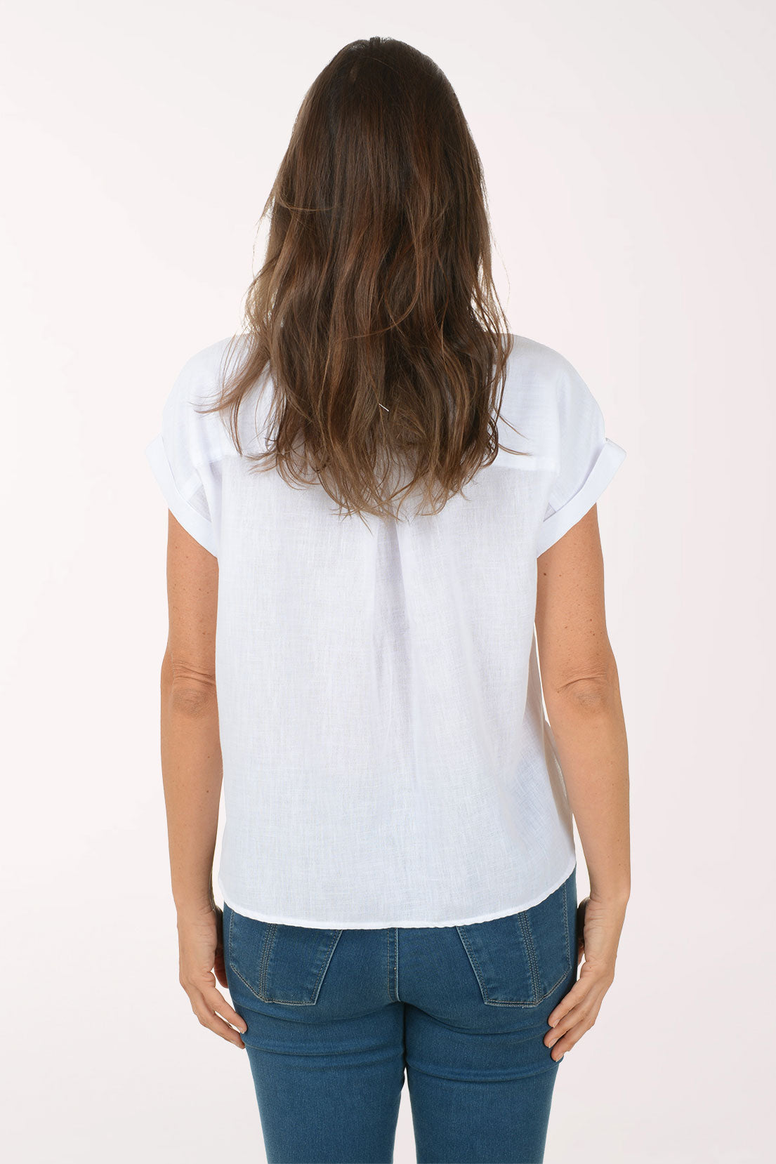 Woman wearing a white short-sleeve shirt and blue jeans on a white background
