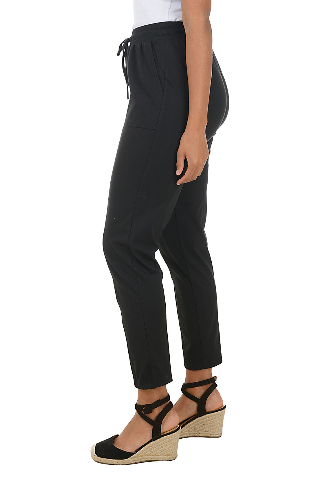 Black pants worn by a person on a white background. Side shot.