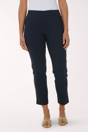 Navy blue pants with white polka dots worn by a person on a white background