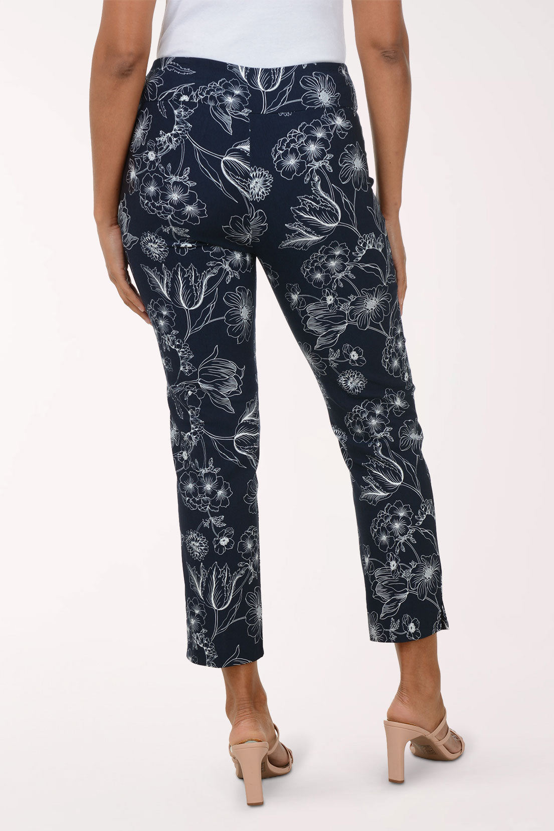Navy pants with white floral pattern worn by a person on a white background