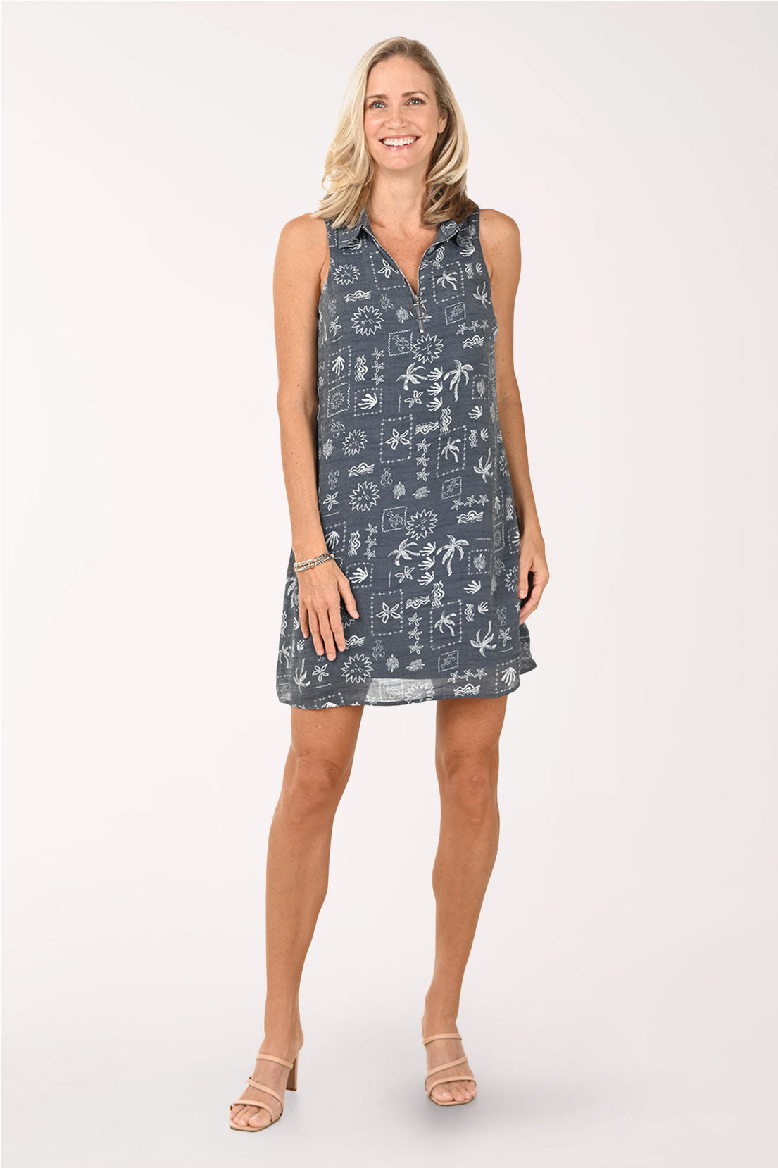 Woman wearing a sleeveless dress with a pattern on a white background