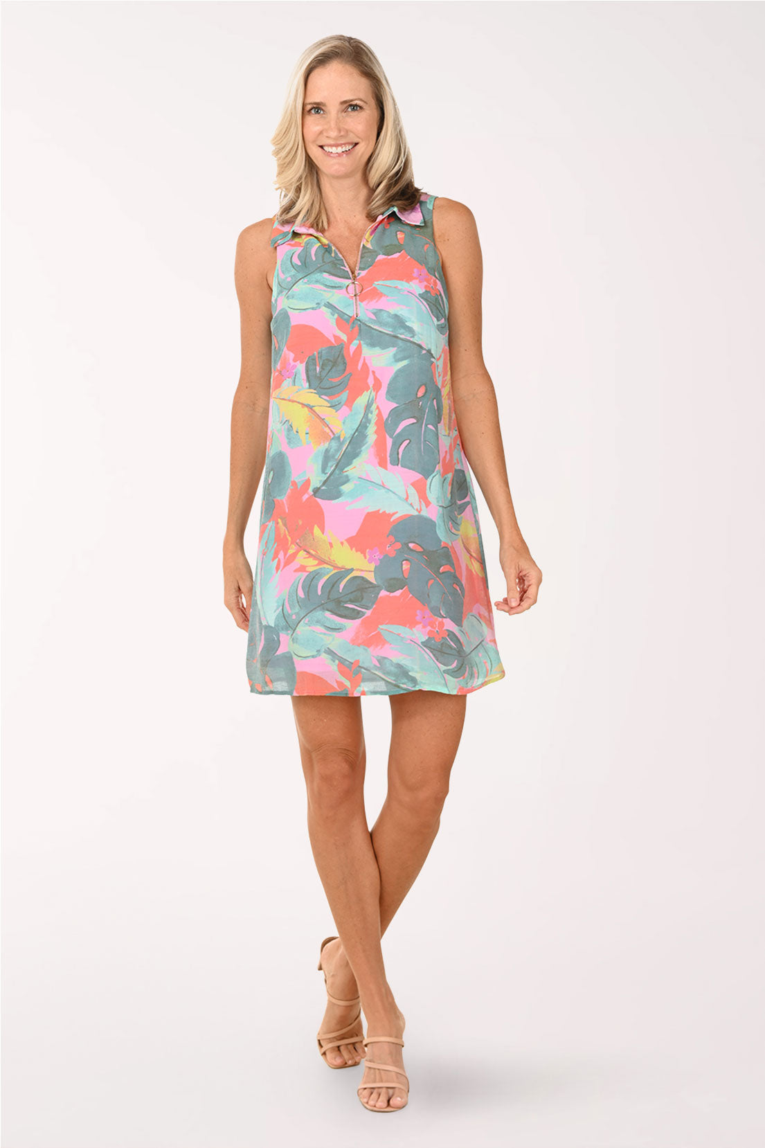 Woman wearing a colorful tropical leaf pattern dress on a white background