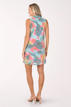 Woman wearing a colorful tropical leaf pattern dress on a white background