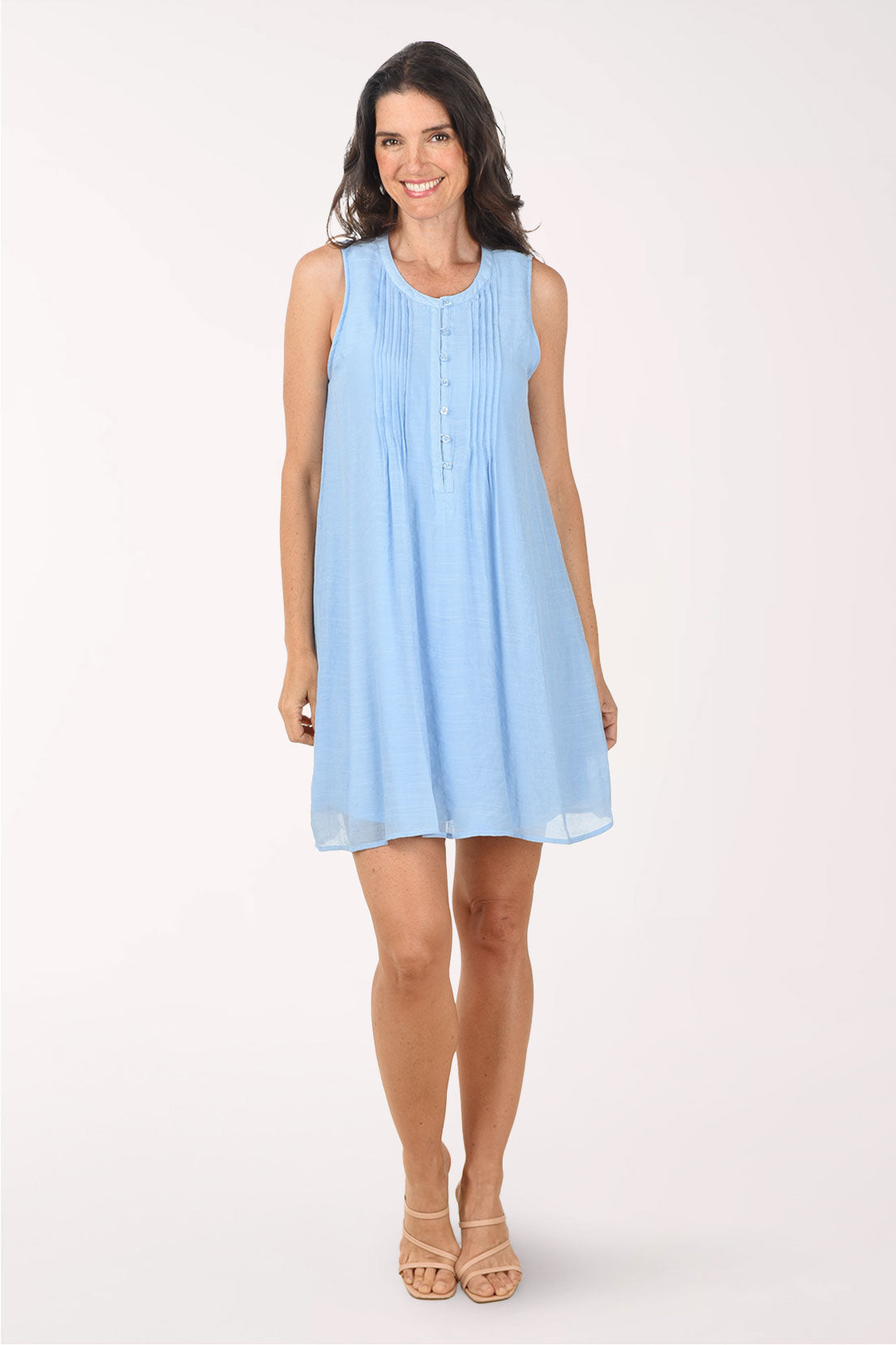 Woman wearing a light blue sleeveless dress on a white background