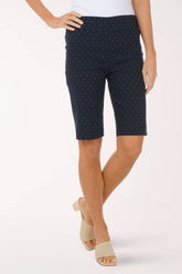 Navy blue polka dot shorts worn by a person on a white background