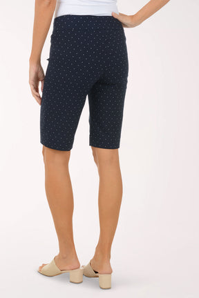 Navy blue polka dot shorts worn by a person on a white background
