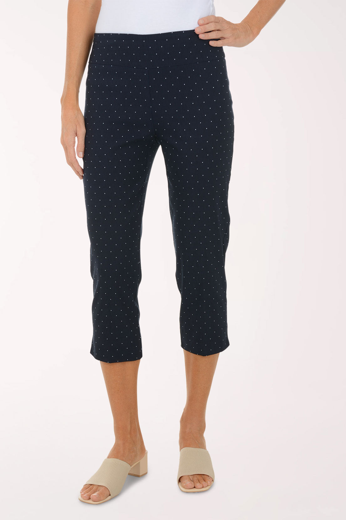Navy blue polka dot pants worn by a person on a white background