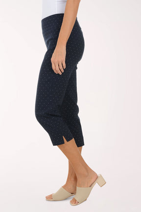 Navy blue polka dot pants worn by a person on a white background