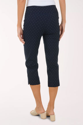 Navy blue polka dot pants worn by a person on a white background