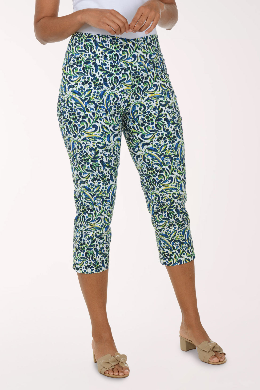 Person wearing a patterned green and blue capri pants on a white background
