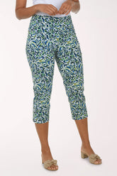 Person wearing a patterned green and blue capri pants on a white background