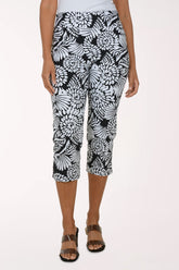 Person wearing black and white patterned capri pants on a white background