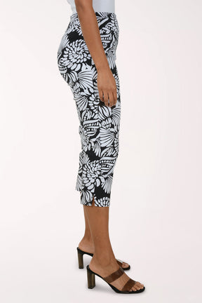 Person wearing black and white patterned capri pants on a white background