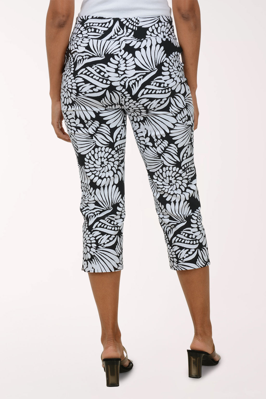 Person wearing black and white patterned capri pants on a white background