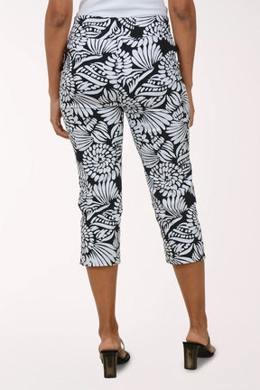 Person wearing black and white patterned capri pants on a white background