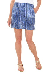 A front shot of a model wearing a blue and white striped pull-on skort with an elasticized waistband, paired with a white top and beige sandals.