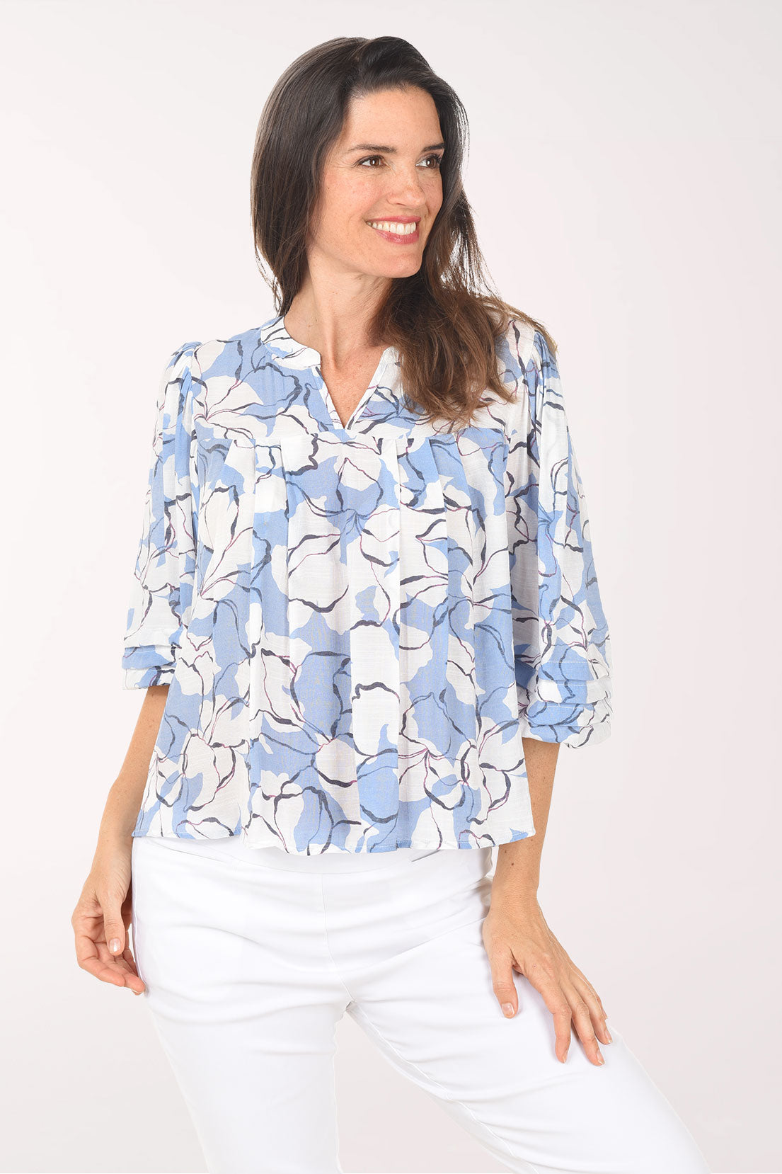 Woman wearing a blue floral blouse against a white background