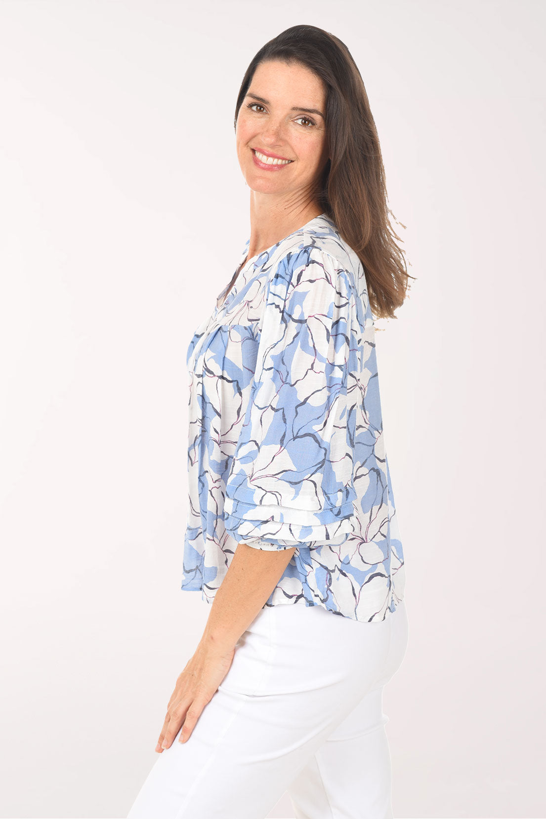 Woman wearing a blue floral blouse against a white background