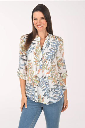 Woman wearing a floral blouse with rolled-up sleeves on a white background