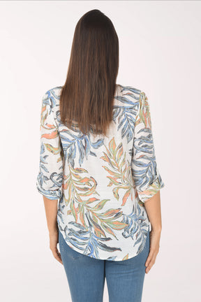 Woman wearing a floral blouse with rolled-up sleeves on a white background