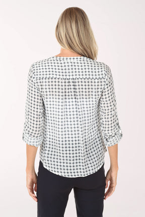 Woman wearing a navy and white checkered blouse with navy pants on a white background