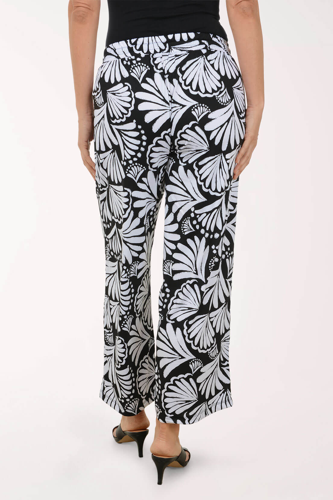 Black and white butterfly-patterned pants worn by a person on a white background