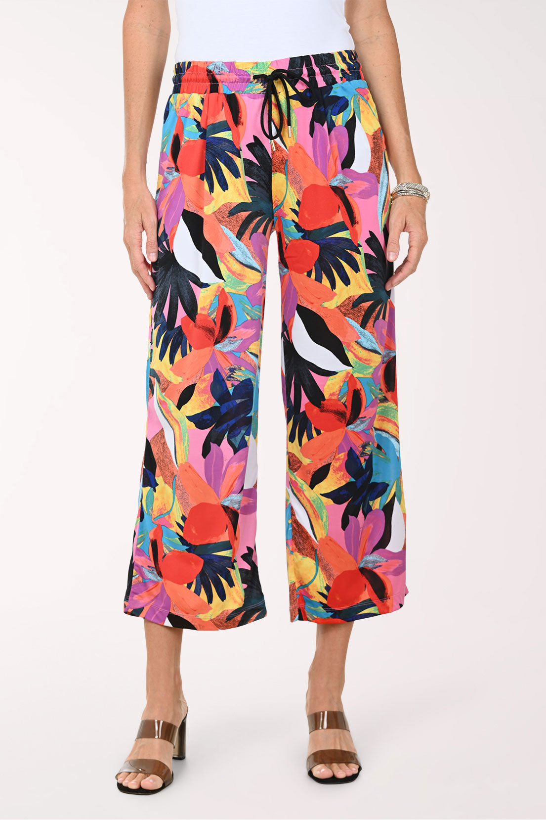 Multicolored tropical print pants worn by a person on a white background