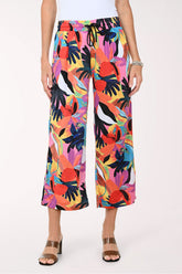 Multicolored tropical print pants worn by a person on a white background