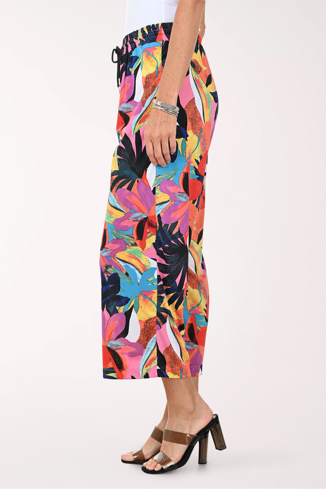 Multicolored tropical print pants worn by a person on a white background