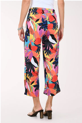 Multicolored tropical print pants worn by a person on a white background