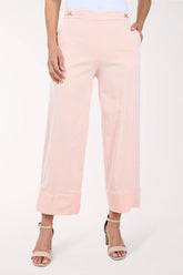 Person wearing light pink pants on a white background